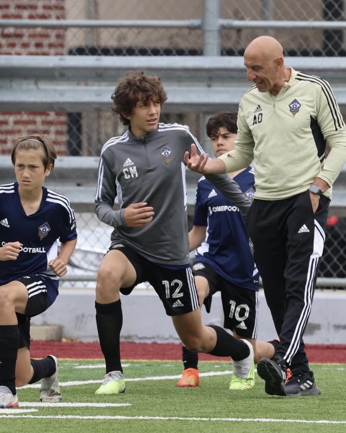 A coach guides young players during a training exercise