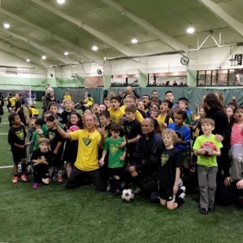 Marcelo Gonçalves with young players on an indoor soccer field